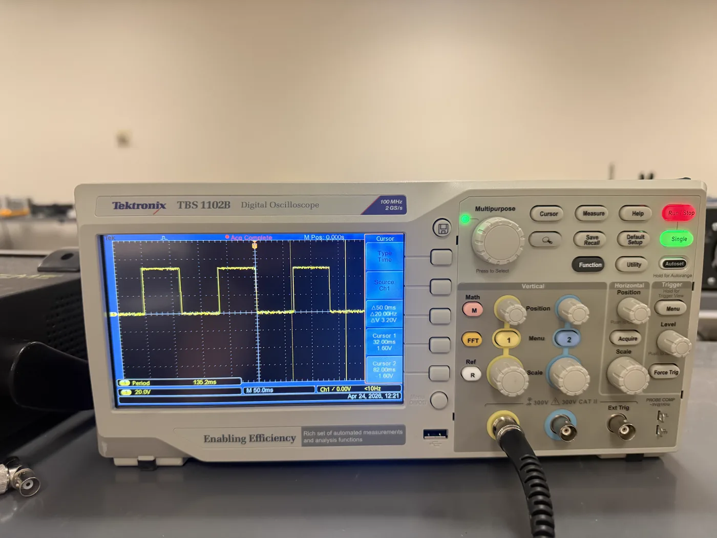 The same oscilloscope with time cursors placed on the waveform: the on-screen readout shows a measured period of 135.2 ms, a 50.0 ms cursor delta, 20.00 Hz, and a 3.20 V amplitude delta.